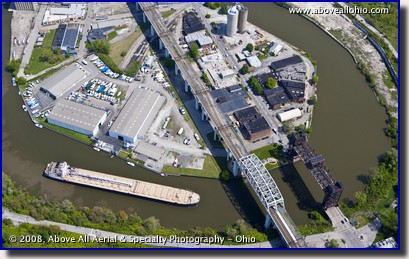 An aerial view of a Great Lakes shipping freighter going around a bend in the Cuyahoga River in the Flats; downtown Cleveland, OH.