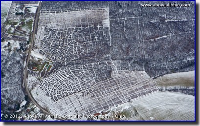 With leafless trees and a light snow cover, paths and other ground features can easily be seen in the woods from the air.